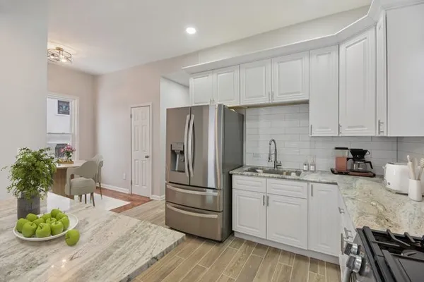 a kitchen with a refrigerator and a wooden floor