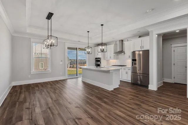 a large kitchen with kitchen island white cabinets and stainless steel appliances