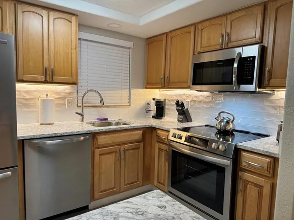 a kitchen with stainless steel appliances a stove microwave and sink