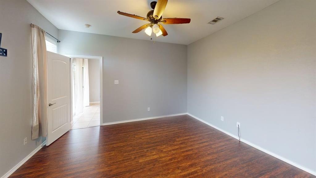 14308 Polo Ranch Street Fort Worth, TX 76052 - Photo 13 of 19 Room featuring wood-finish flooring, light grey painted walls, and a ceiling fan with integrated lighting