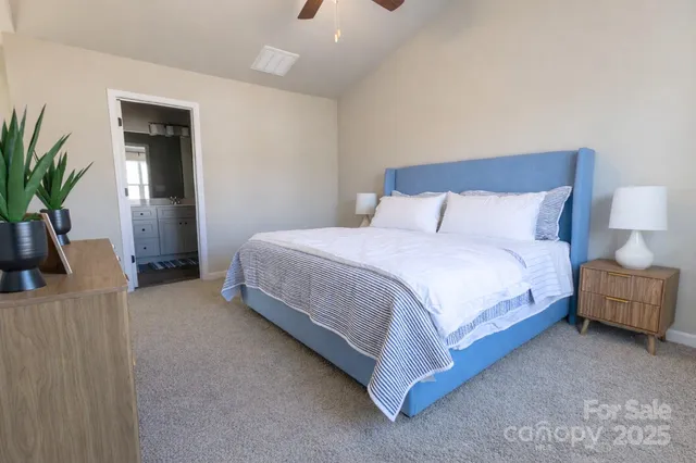 a bedroom with a bed and a potted plant on table