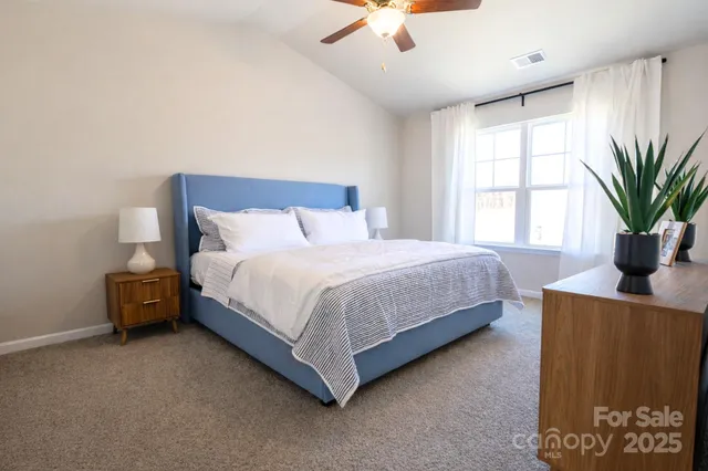 a bedroom with a large bed and a potted plant
