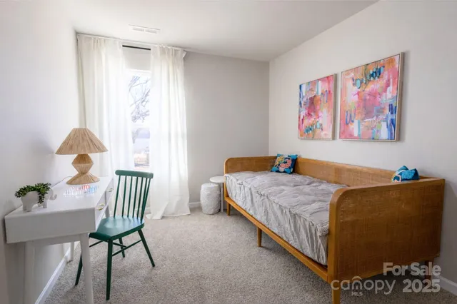 a bedroom with a bed and a chair with potted plant