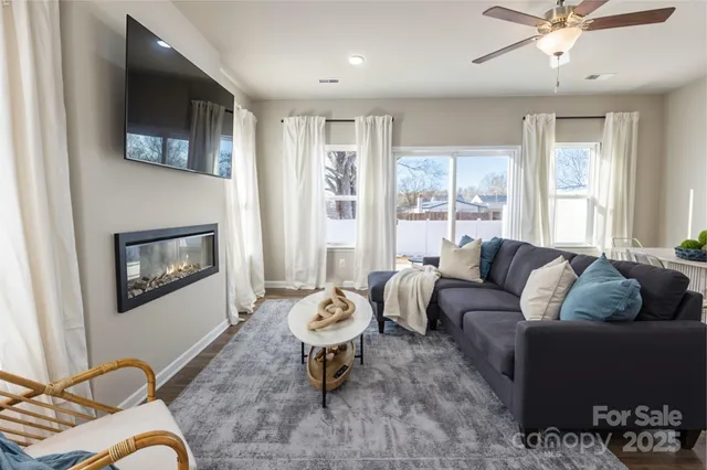 a living room with furniture a flat screen tv and a window