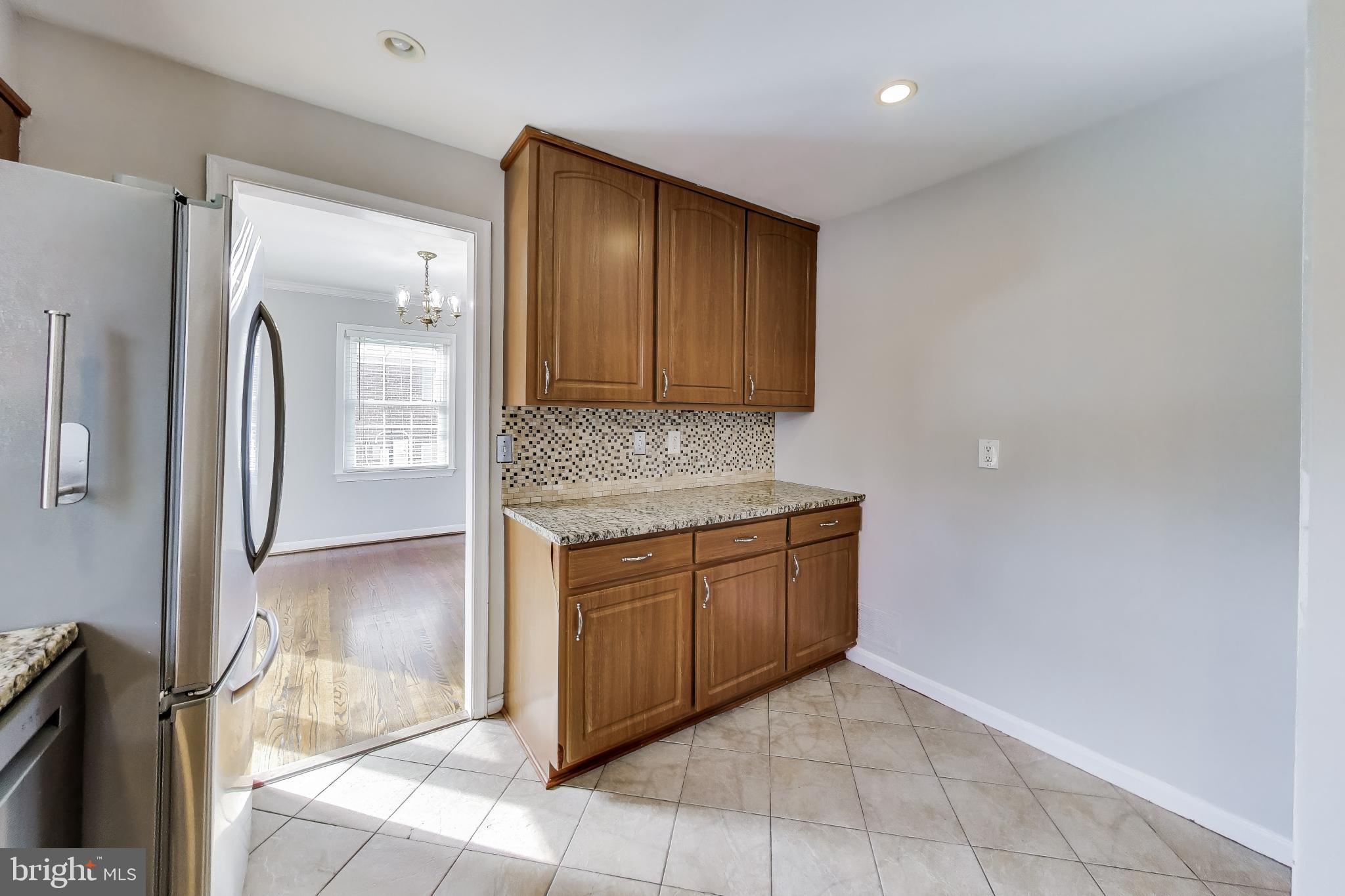 5300 Easton Drive Springfield, VA 22151 - Photo 13 of 60 a kitchen with granite countertop a refrigerator and a stove top oven
