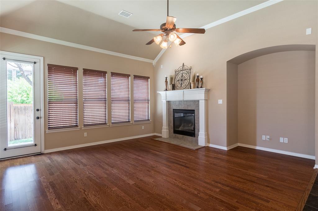911 Panther Lane Allen, TX 75013 - Photo 7 of 20 an empty room with wooden floor fireplace and windows