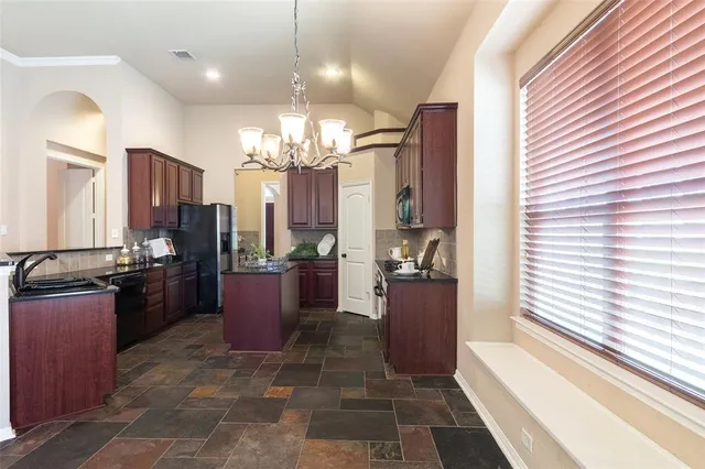 a large kitchen with a counter space a sink and stainless steel appliances