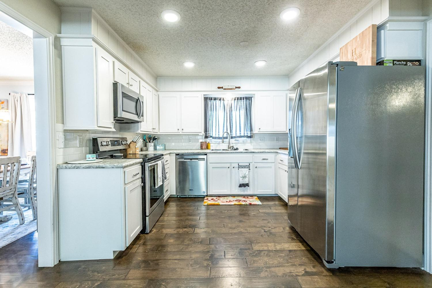 5720 68th Street Lubbock, TX 79424 - Photo 13 of 48 a kitchen with stainless steel appliances granite countertop a refrigerator sink and cabinets