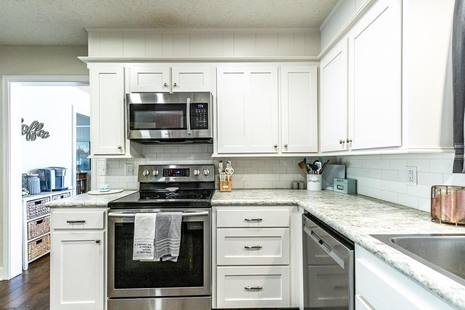 5720 68th Street Lubbock, TX 79424 - Photo 14 of 48 a kitchen with granite countertop a stove and a sink