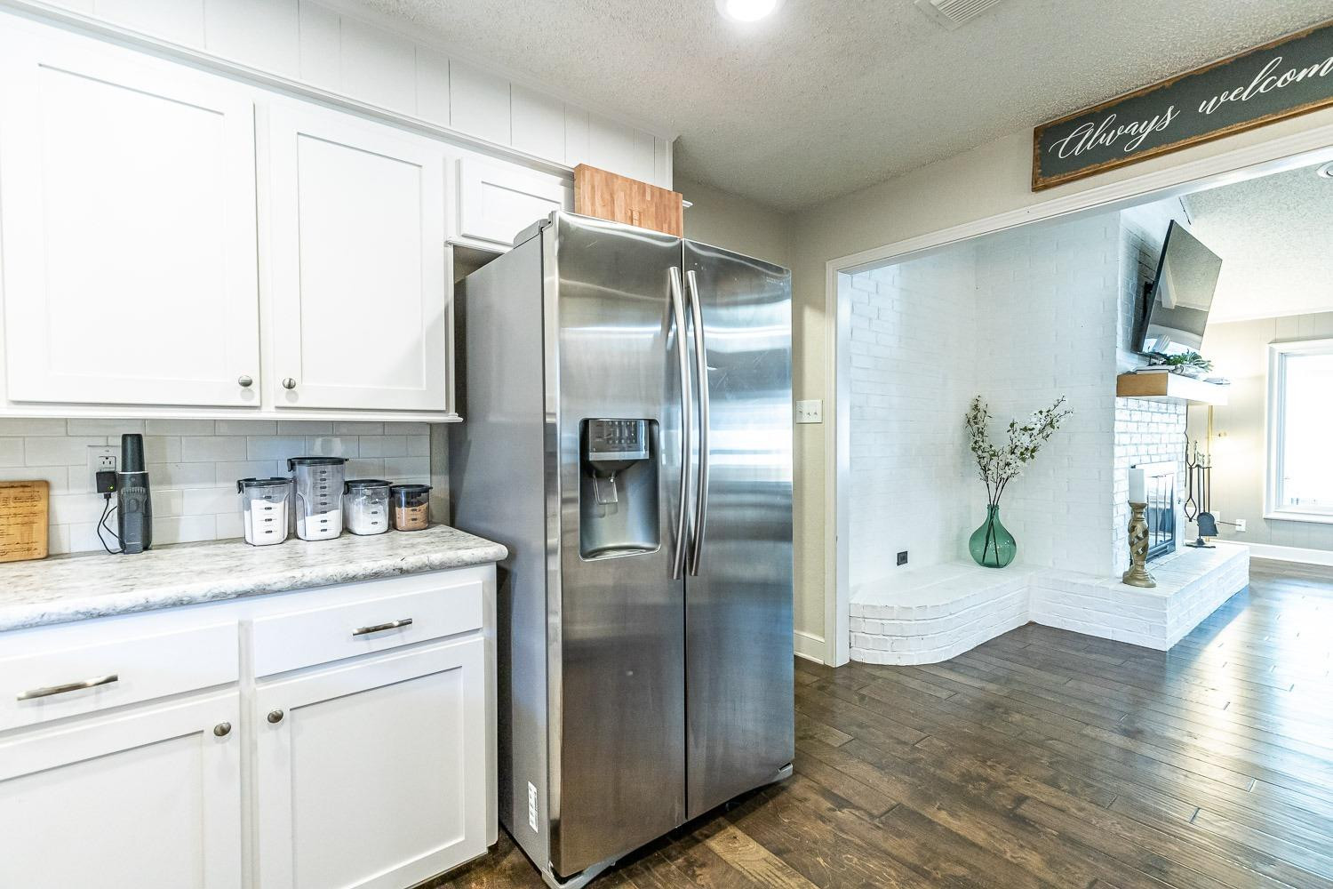 5720 68th Street Lubbock, TX 79424 - Photo 15 of 48 a kitchen with stainless steel appliances a refrigerator and a hard wood floor
