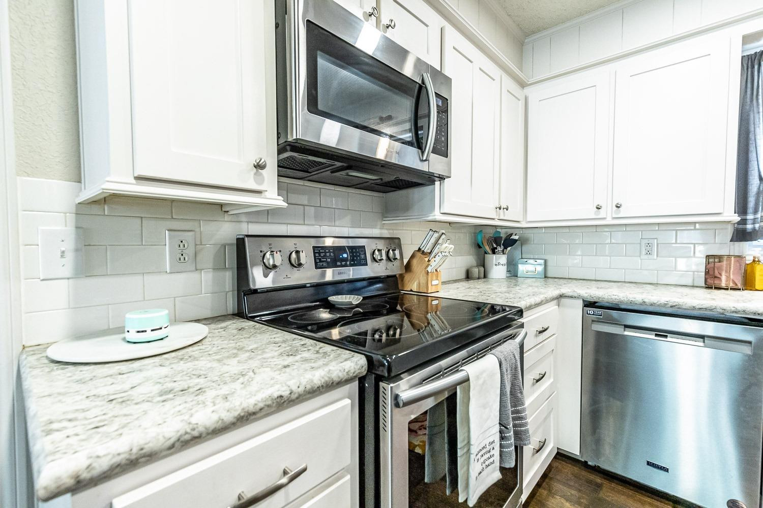 5720 68th Street Lubbock, TX 79424 - Photo 16 of 48 a kitchen with stainless steel appliances granite countertop a stove and a microwave