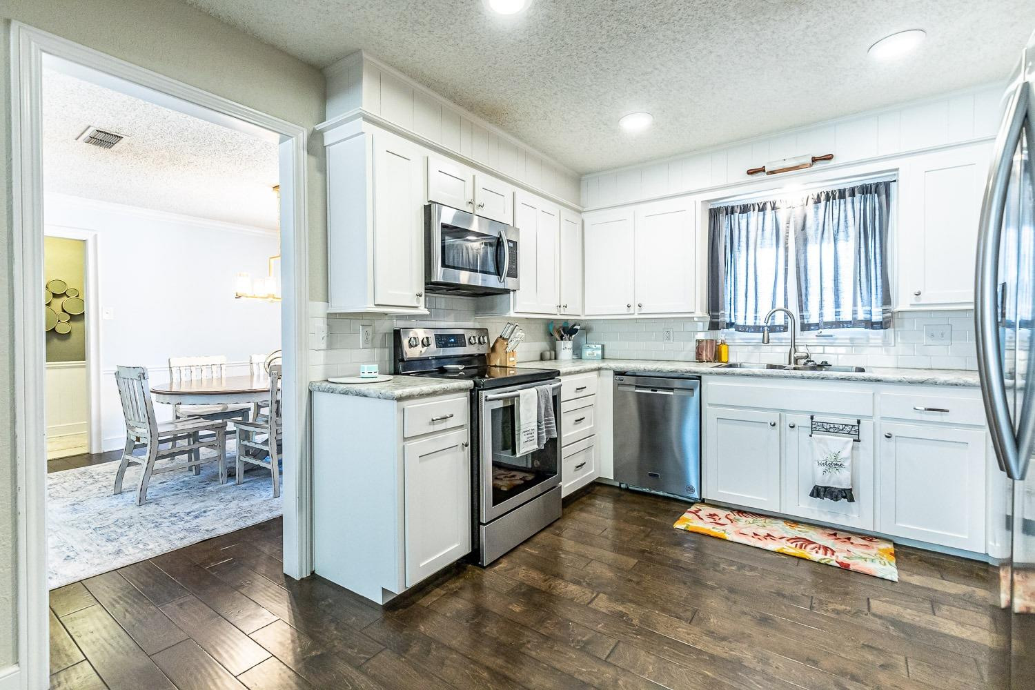 5720 68th Street Lubbock, TX 79424 - Photo 17 of 48 a kitchen with white cabinets and appliances