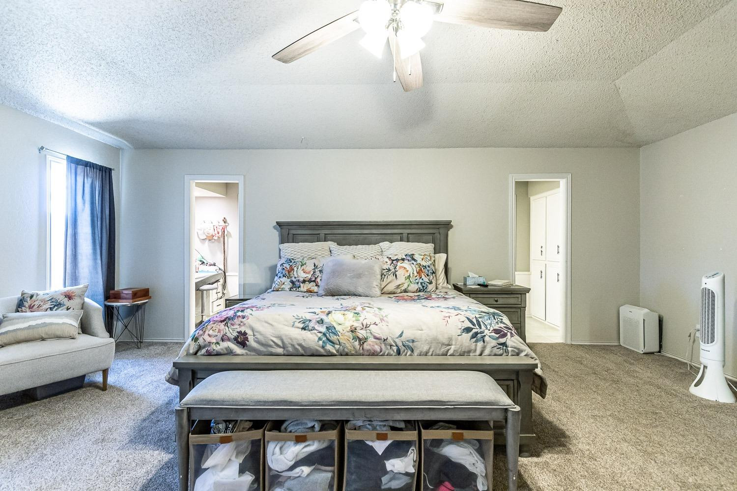 5720 68th Street Lubbock, TX 79424 - Photo 19 of 48 a bedroom with a bed and a chandelier