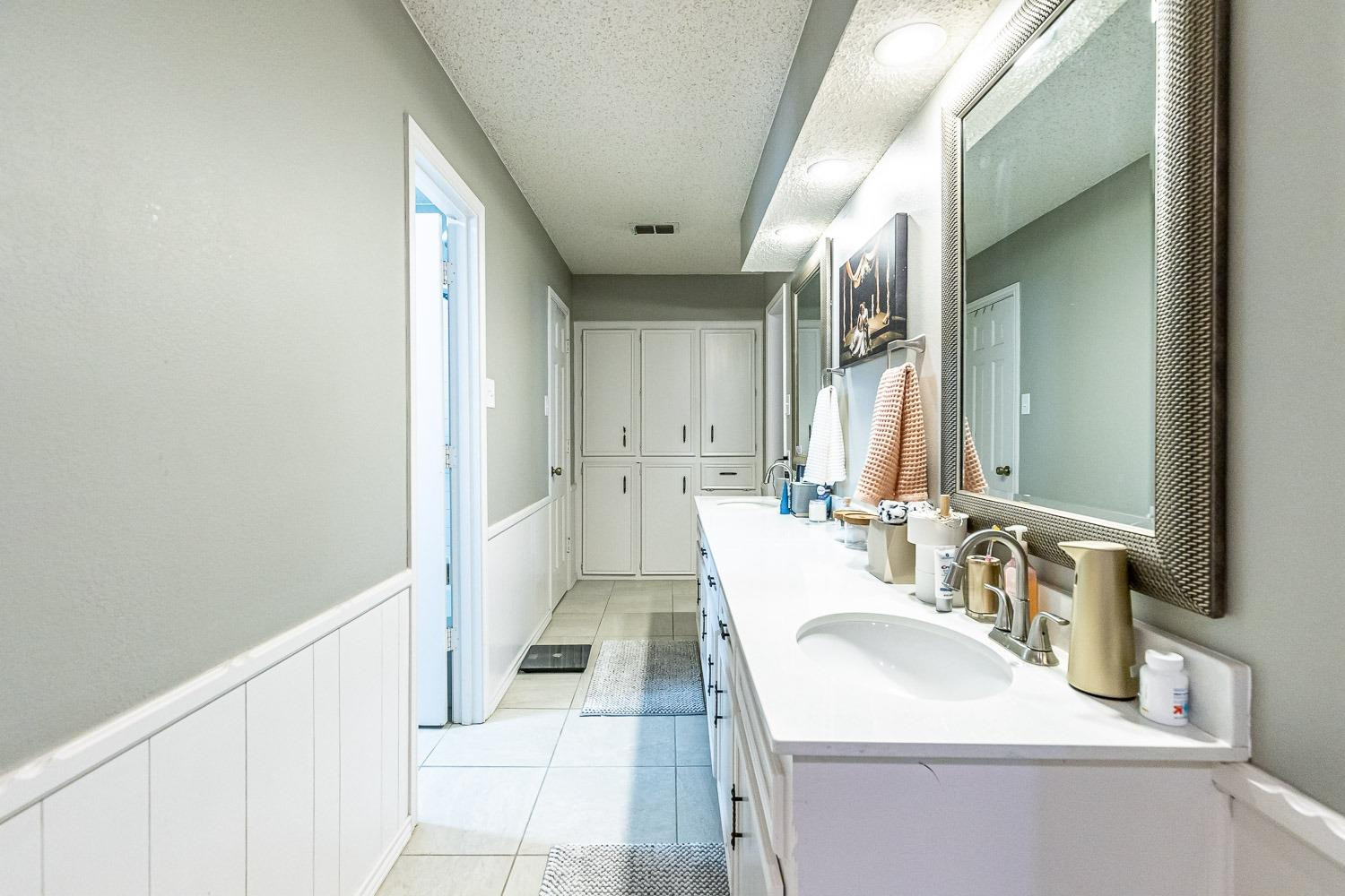 5720 68th Street Lubbock, TX 79424 - Photo 21 of 48 a bathroom with a sink and a mirror