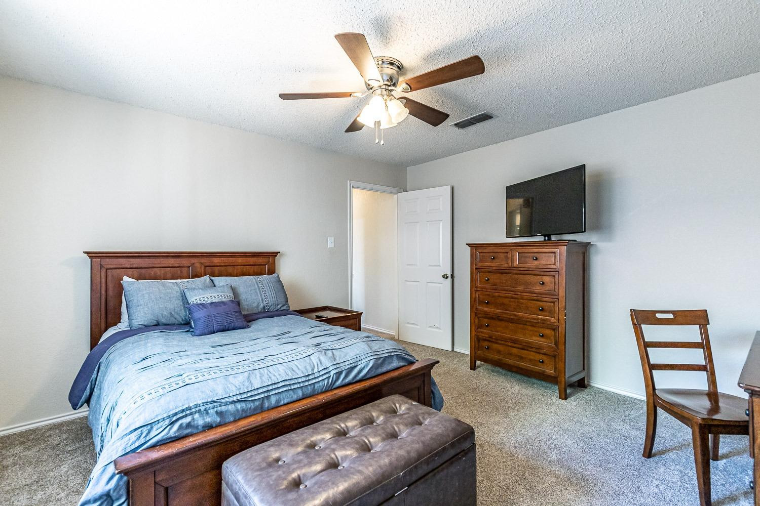 5720 68th Street Lubbock, TX 79424 - Photo 24 of 48 a bed room with a bed and a television