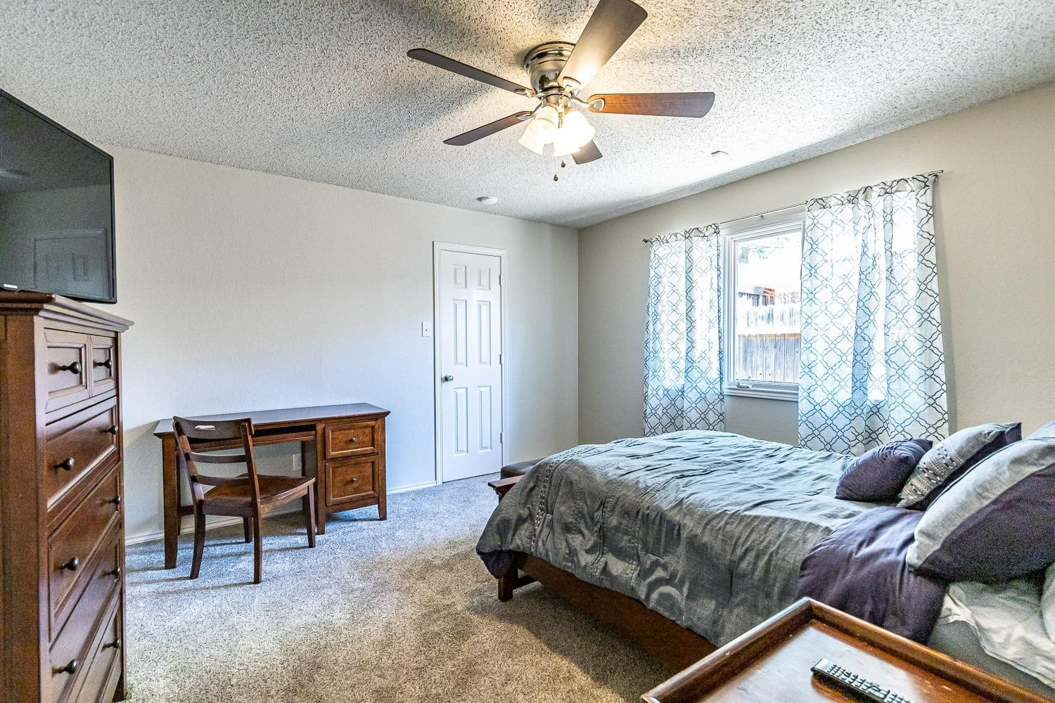 5720 68th Street Lubbock, TX 79424 - Photo 25 of 48 a bedroom with a bed and a chandelier