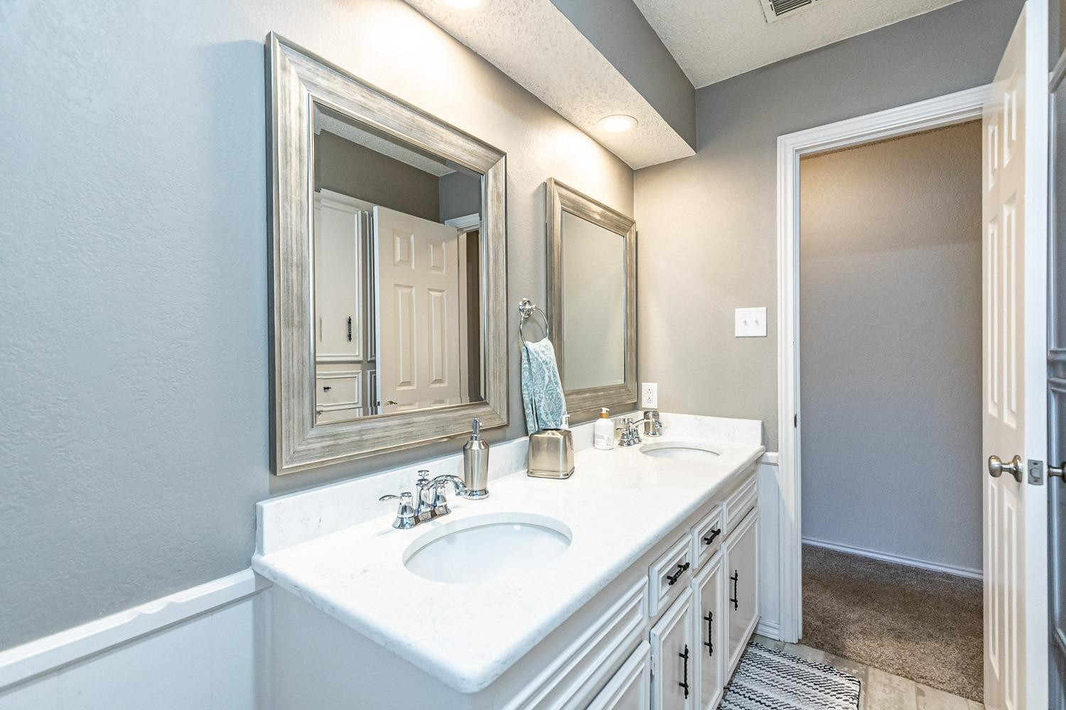 5720 68th Street Lubbock, TX 79424 - Photo 28 of 48 a bathroom with a sink and a mirror