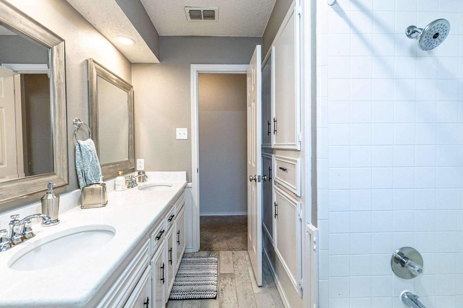 5720 68th Street Lubbock, TX 79424 - Photo 29 of 48 a bathroom with a double vanity sink and mirror
