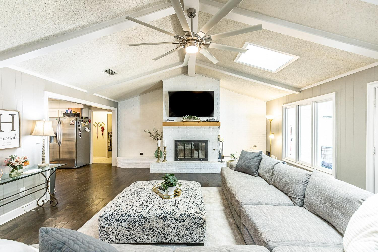 5720 68th Street Lubbock, TX 79424 - Photo 9 of 48 a living room with furniture a fireplace and a flat screen tv