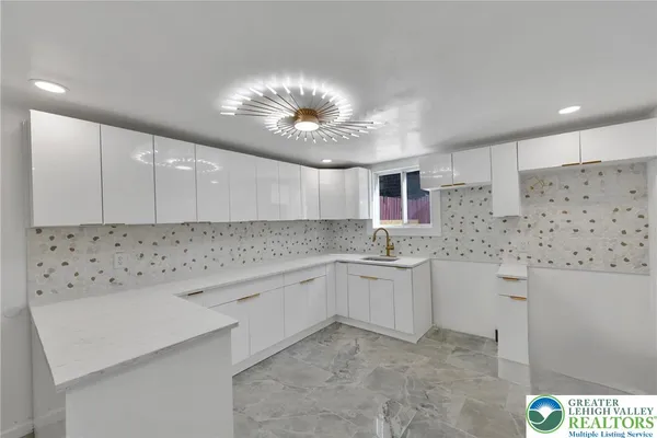 a kitchen with granite countertop a sink and dishwasher a stove with wooden floor