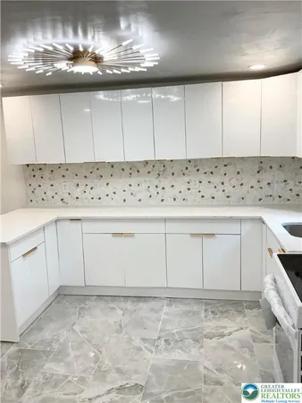 a kitchen with white cabinets and sink