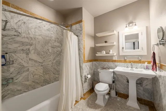 a bathroom with a granite countertop toilet a sink and a bathtub