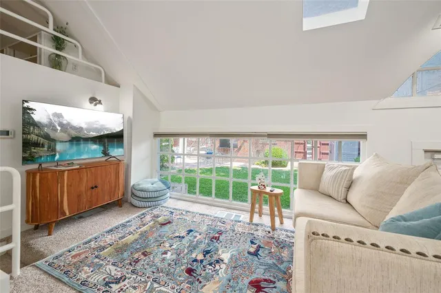 a living room with stainless steel appliances furniture and a kitchen view