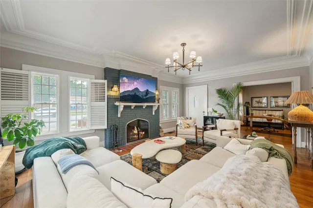 a living room with furniture a chandelier and a fireplace