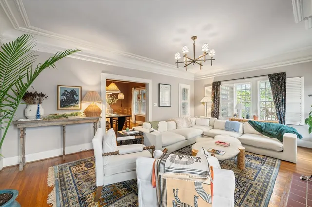 a living room with furniture a chandelier and a dining table