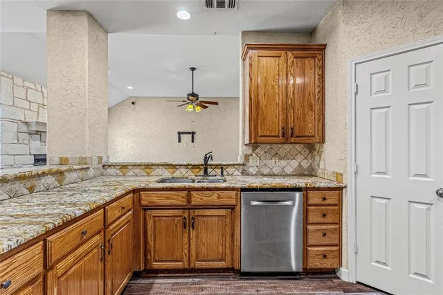 a kitchen with granite countertop cabinets sink and wooden floor
