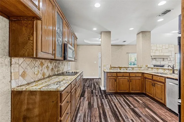 a kitchen with granite countertop cabinets sink and wooden floor