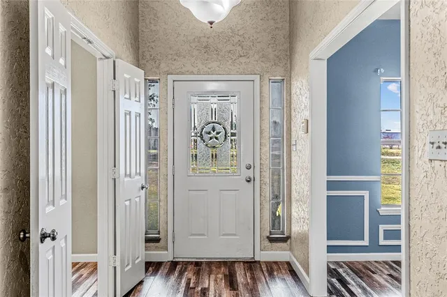 a view of a hallway with wooden floor and closet