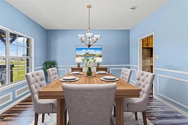 a dining room with furniture a chandelier and wooden floor