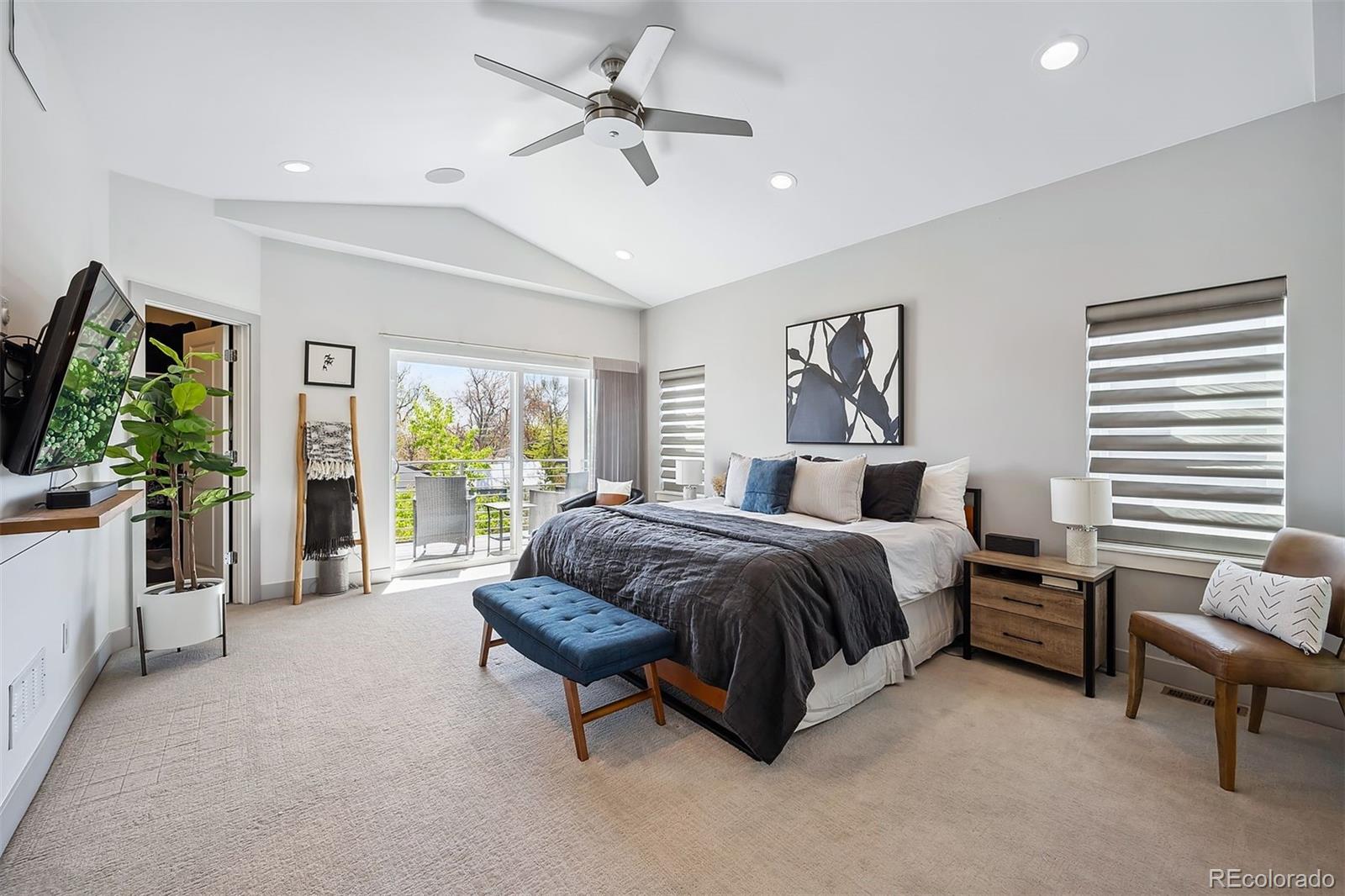 3536 Tejon Street Denver, CO 80211 - Photo 13 of 33 a spacious bedroom with a bed a couch and a flat tv screen