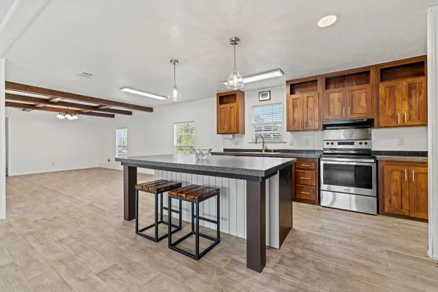 a kitchen with stainless steel appliances granite countertop a stove a sink and a refrigerator