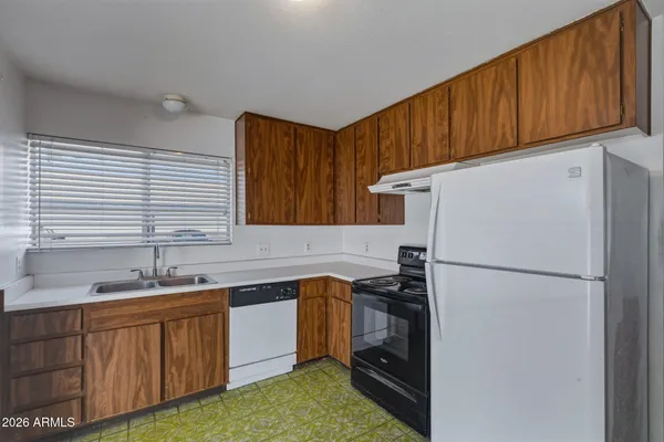 a kitchen with a sink a refrigerator and cabinets