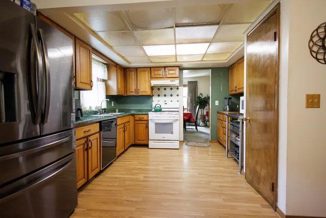 a kitchen with granite countertop wooden cabinets stainless steel appliances and a window
