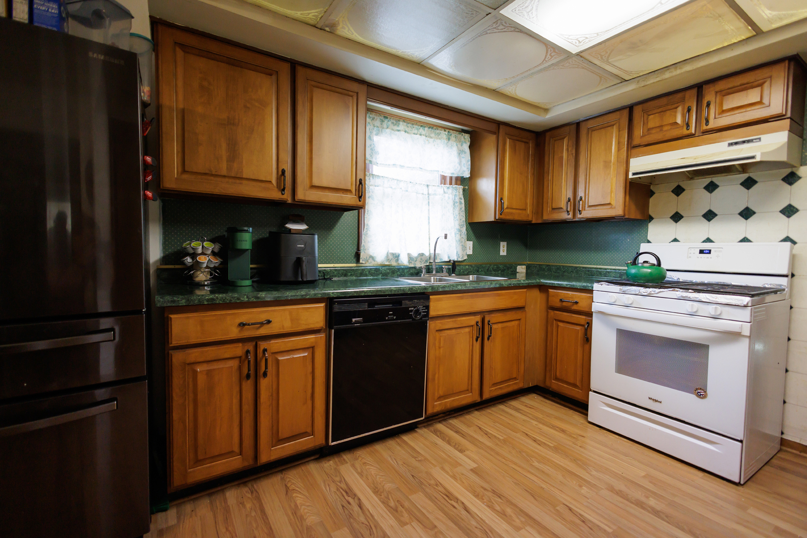 824 South McKinley Avenue Kankakee, IL 60901 - Photo 14 of 58 a kitchen with granite countertop wooden cabinets stainless steel appliances and a window