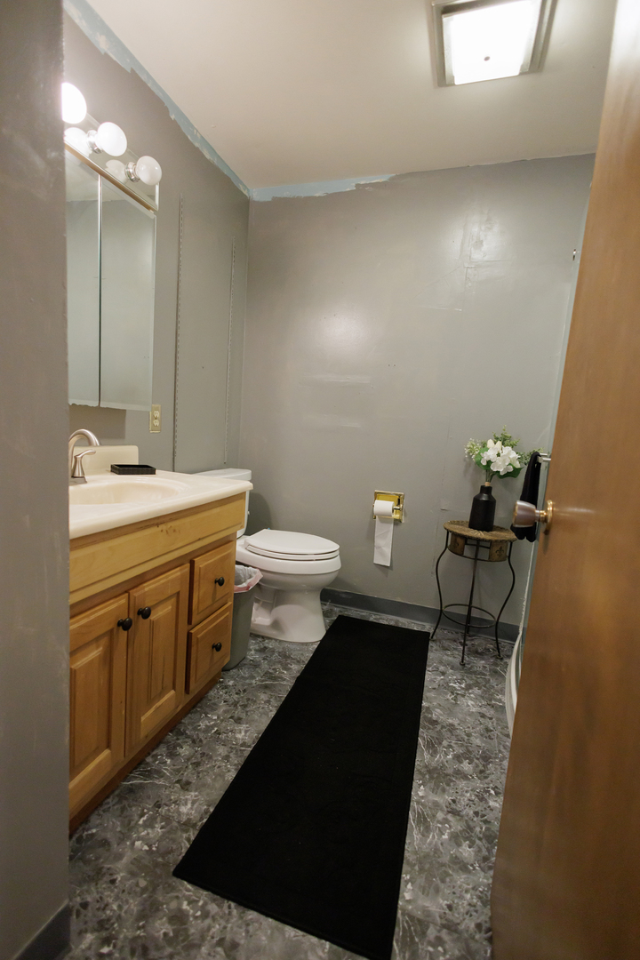 824 South McKinley Avenue Kankakee, IL 60901 - Photo 29 of 58 a bathroom with a sink a toilet a mirror and vanity