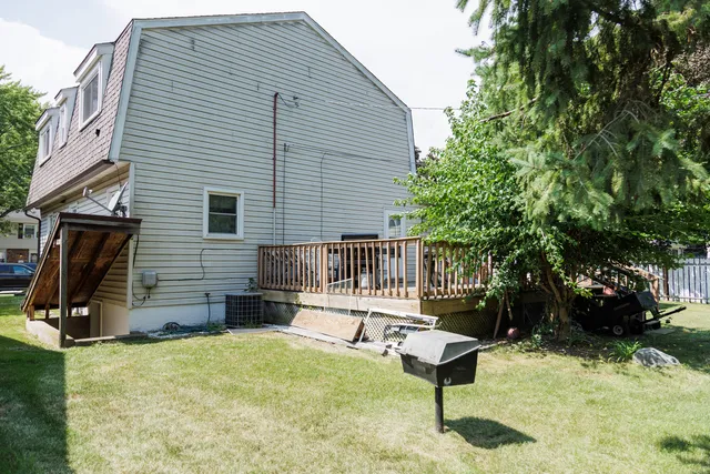a backyard of a house with a bench and trees