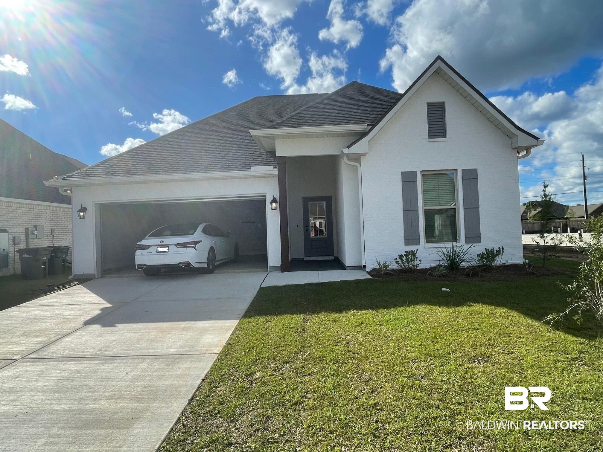1586 Fenton Circle Foley, AL 36535 - Photo 1 of 3 View of front of property featuring a front lawn, concrete driveway, an attached garage, and a shingled roof
