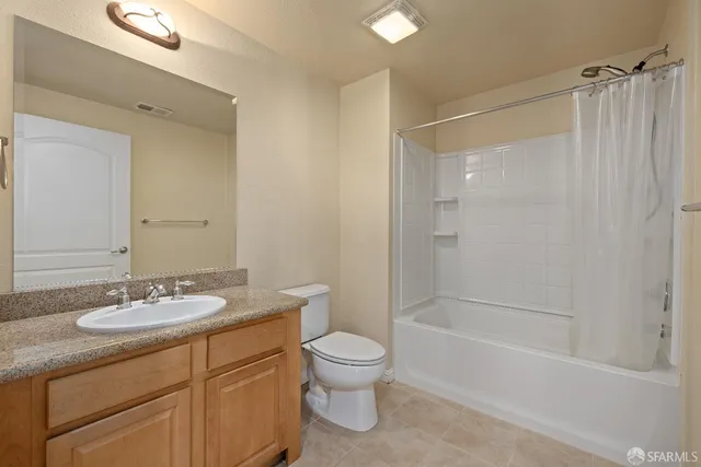 a bathroom with a granite countertop sink a toilet and shower
