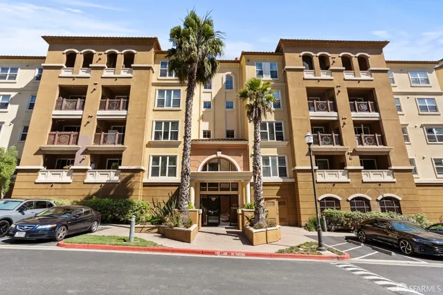 a front view of a building with parking space and windows