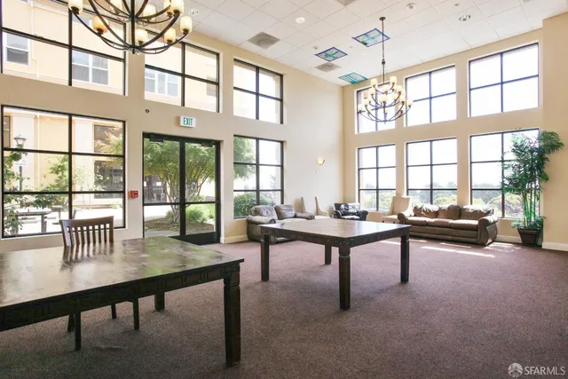 a living room with furniture a table and large windows