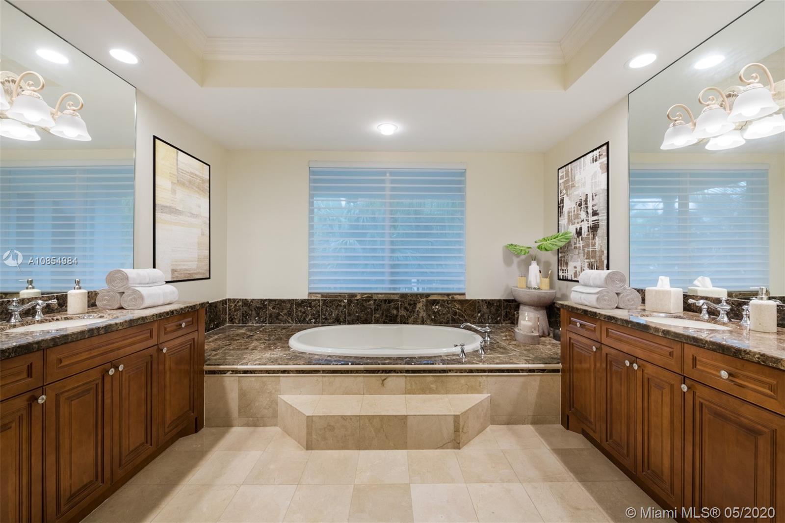 1475 Commodore Way Hollywood, FL 33019 - Photo 24 of 49 a spacious bathroom with a granite countertop double vanity sink large mirror and a bathtub