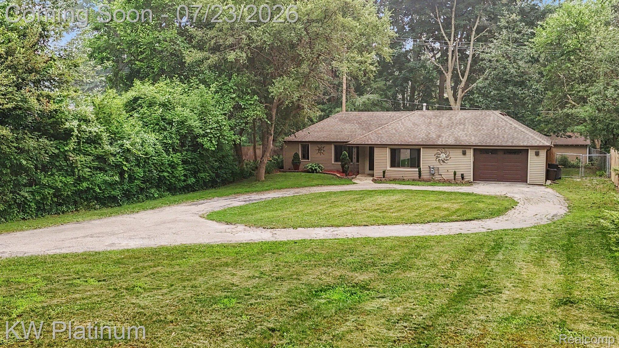 4885 Lakeshore Road Fort Gratiot, MI 48059 - Photo 5 of 26 Ranch-style residence featuring a circular driveway, an attached single-car garage with a brown door, and a light-colored exterior facade