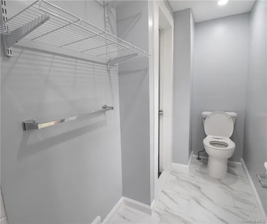 a white toilet sitting next to a bathroom sink