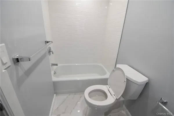 a bathroom with a toilet and a tub