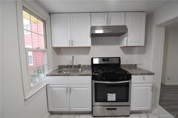 a kitchen with white cabinets and appliances