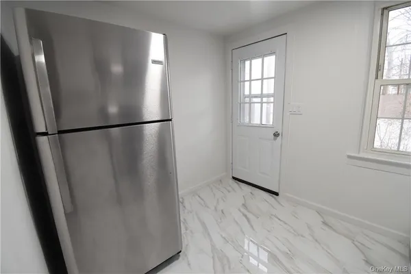 a view of empty room with wooden floor and window